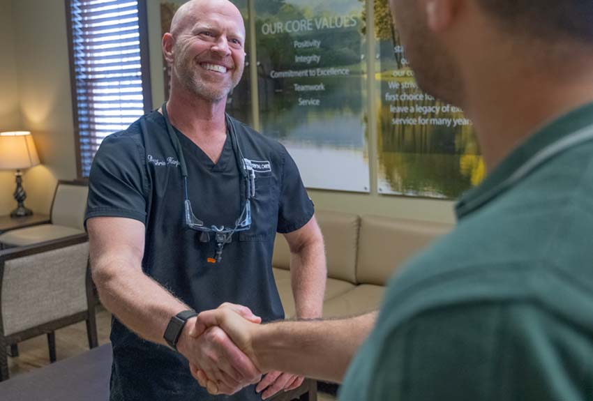 Dr. Harper shakes hands with a middle aged male patient in the lobby
