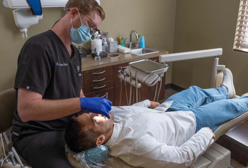 Dr. Baker performing an examination on a adult patient in a dental chair.