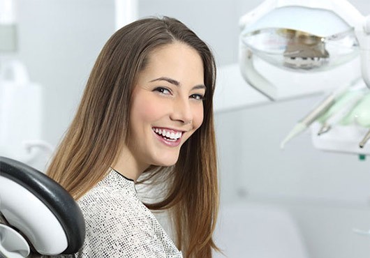 Young woman sitting in a dental chair smiling