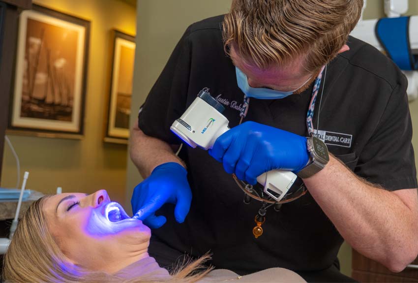 Dr. Baker performing a cancer screening with a Veloscope on a female patient