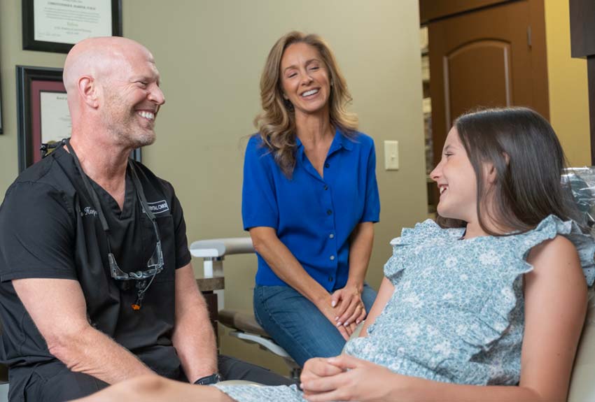 Mom and Daughter laughing with Dr. Harper after daughter's exam.