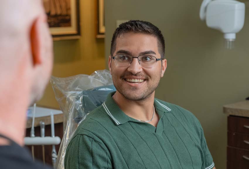 middle aged man sitting in a dental chair smiling
