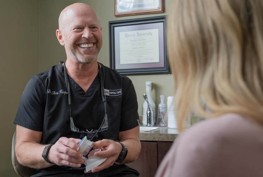 Dr. Harper holding a somnodent device while having a consultation with a female patient